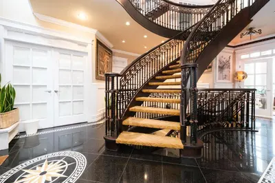 a spiral staircase in a home with black tile floors at Luxurious & Spacious Mansion next to Oakridge Mall in Vancouver