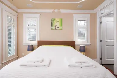 a bedroom with a large white bed with two towels at Luxurious & Spacious Mansion next to Oakridge Mall in Vancouver