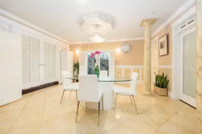 a dining room with a glass table and white chairs at Luxurious & Spacious Mansion next to Oakridge Mall in Vancouver