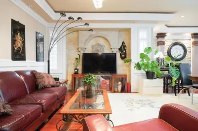 a living room with a couch and a tv at Luxurious & Spacious Mansion next to Oakridge Mall in Vancouver