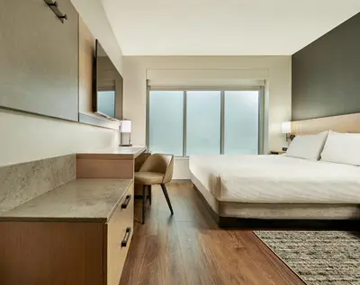 a bedroom with a bed and a desk with a chair at Hyatt Place Vancouver/Metrotown in Burnaby