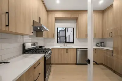 a kitchen with wooden cabinets and a stove top oven at Luxury 5BR Modern Home Huge Open Layout in Langley