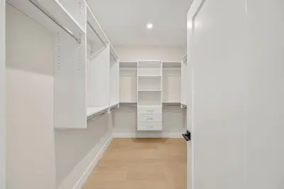 a walk in closet with white cabinets and a door at Luxury 5BR Modern Home Huge Open Layout in Langley
