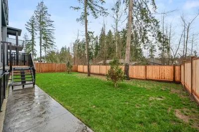 a backyard with a wooden fence and a yard at Luxury 5BR Modern Home Huge Open Layout in Langley
