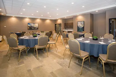 a conference room with round tables and chairs at Wingate by Wyndham Calgary Airport in Calgary