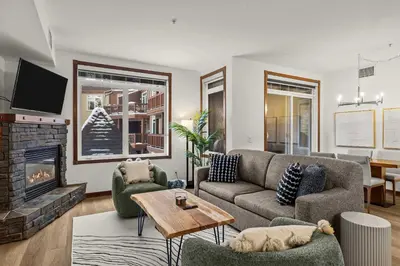 a living room with a couch and a fireplace at Modern 1 Bedroom Retreat with Sofa Bed Comfort & Convenience Combined in Canmore