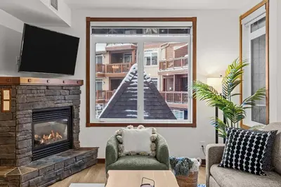 a living room with a fireplace and a tv at Modern 1 Bedroom Retreat with Sofa Bed Comfort & Convenience Combined in Canmore
