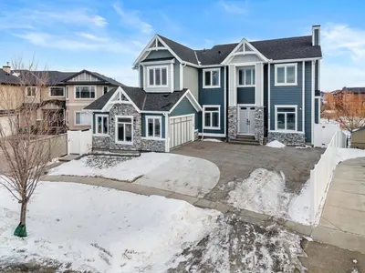 a large blue house with a driveway at 1BR Entertainment Space Projector and Games Room in Airdrie