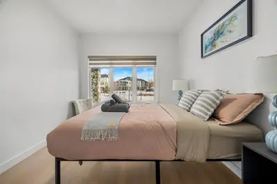 a bedroom with a large bed with a window at Waterfront 1BR Suite Private and Modern and Queen Bed in Airdrie