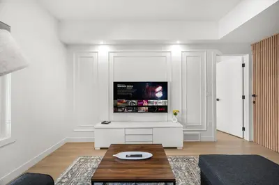 a living room with a tv on a white wall at Waterfront 1BR Suite Private and Modern and Queen Bed in Airdrie