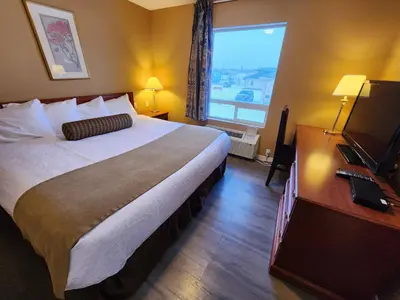 a hotel room with a large bed and a window at Fox Creek Inn in Fox Creek