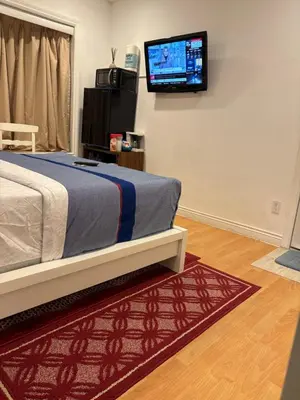 a bedroom with a bed and a flat screen tv on the wall at private 1br guest suite Vancouver in Vancouver