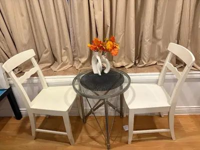 a glass table with two chairs and a vase with flowers at private 1br guest suite Vancouver in Vancouver