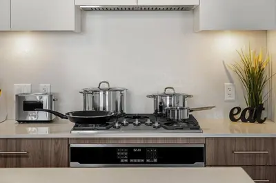 a kitchen with two pots and pans on a stove at Dt Spacious and Vibrant | Kng Bed| Outdoor patio in Calgary