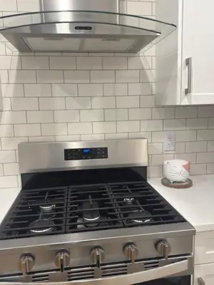 a stove top oven in a white kitchen at Cozy 1bedroom Mainfloor in Calgary