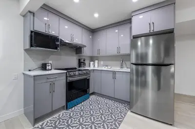 a kitchen with white cabinets and a stainless steel refrigerator at Brand New 3 Bedroom, 2 Washroom, Kitchen and Ensuite in Chestermere