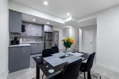 a kitchen and dining room with a table and chairs at Brand New 3 Bedroom, 2 Washroom, Kitchen and Ensuite in Chestermere