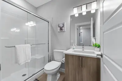 a bathroom with a toilet and a sink and a shower at Brand New Modern Home - 5 Beds - Office - Garage - Luxury Living - Sleeps 9 in Calgary