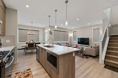 a kitchen and living room with a sink and a counter at Brand New Modern Home - 5 Beds - Office - Garage - Luxury Living - Sleeps 9 in Calgary