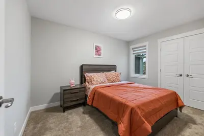 a bedroom with a bed and a dresser and a window at Brand New Modern Home - 5 Beds - Office - Garage - Luxury Living - Sleeps 9 in Calgary