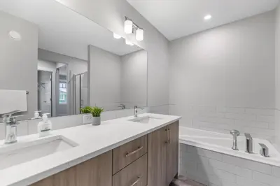 a bathroom with two sinks and a large mirror at Brand New Modern Home - 5 Beds - Office - Garage - Luxury Living - Sleeps 9 in Calgary