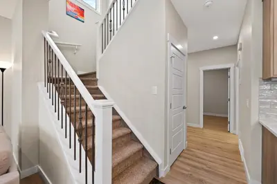 a staircase in a home with white walls and wooden floors at Brand New Modern Home - 5 Beds - Office - Garage - Luxury Living - Sleeps 9 in Calgary