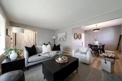 a living room with a couch and a table at Newly Renovated, Bright & Cozy 3 bdrm Home - 6min from Rogers Arena in Edmonton