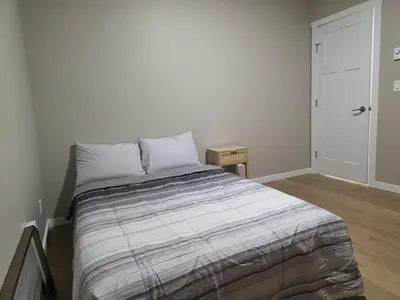 a bedroom with a bed with a striped blanket at Whitehorse Guest Stay in Whitehorse