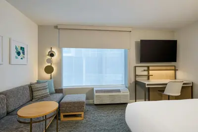 a living room with a couch and a tv at TownePlace Suites by Marriott Victoria Airport Sidney in Sidney