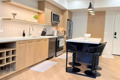 a kitchen with a counter and a sink and a stove at Canmore Peaks Retreat | Luxe 1BR w Pool & Gym in Canmore