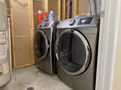 a washing machine and a dryer in a room at Spacious 4BR with King Suite - Garage - Netflix in Lloydminster