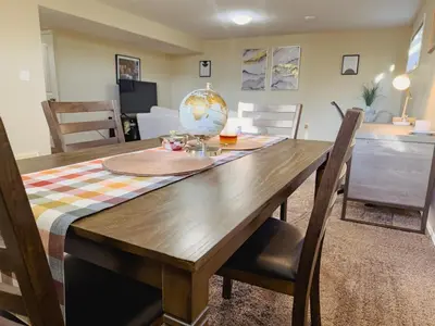 a wooden dining room table with chairs and a table at Spacious 4BR with King Suite - Garage - Netflix in Lloydminster