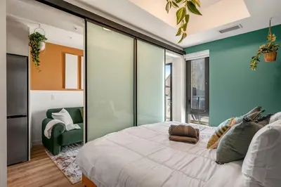 a bedroom with a large bed and a green wall at Incredible DT Views| King bed| Rest and Unwind in Calgary