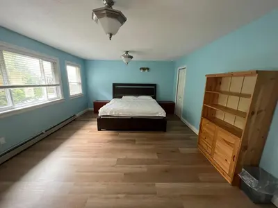 a bedroom with blue walls and a bed and a wooden floor at Bright, modern & spacious luxurious Master Bedroom in prime Golden village Richmond, in Richmond