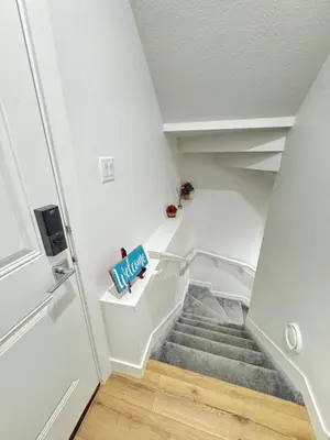 a staircase in a house with a white stair case at Stylish and Cozy 2-Bedroom Guest Suite in West Edmonton in Edmonton