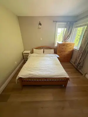 a bedroom with a large bed in a room with a window at BRIGHT & MODERN QUEEN Room, in Golden Village Richmond in Richmond