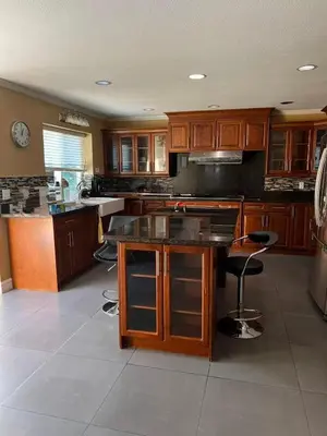 a large kitchen with wooden cabinets and a counter at BRIGHT & MODERN QUEEN Room, in Golden Village Richmond in Richmond