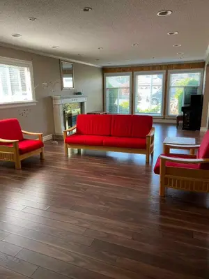 a living room with a red couch and two chairs at BRIGHT & MODERN QUEEN Room, in Golden Village Richmond in Richmond
