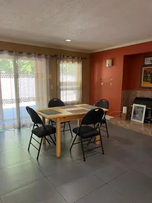 a dining room with a wooden table and chairs at BRIGHT & MODERN QUEEN Room, in Golden Village Richmond in Richmond