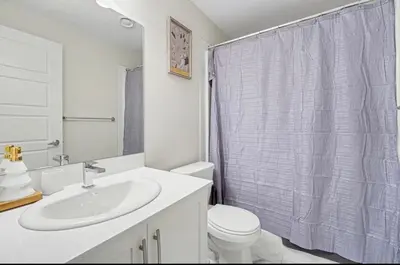 a white bathroom with a sink and a toilet at Luxury brand new 1 Bedroom Townhome in Calgary