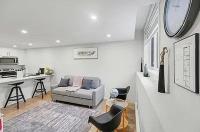 a living room with a couch and a kitchen at Luxury brand new 1 Bedroom Townhome in Calgary