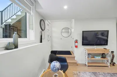 a living room with a television and a chair at Luxury brand new 1 Bedroom Townhome in Calgary