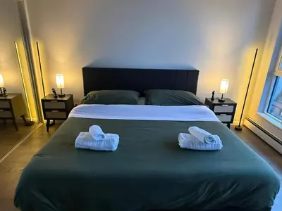a bed with two towels on top of it at Extra Spacious with a King Bed Sauna Pool & Jacuzzi in Vancouver