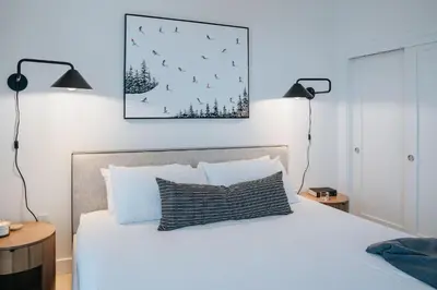 a bedroom with a bed with two lamps and a picture on the wall at Gary's Birthday by Revelstoke Vacations in Revelstoke