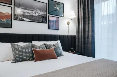 a bedroom with a white bed with pillows at Gary's Birthday by Revelstoke Vacations in Revelstoke