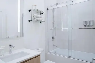a white bathroom with a shower and a sink at Gary's Birthday by Revelstoke Vacations in Revelstoke