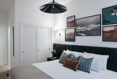 a bedroom with a bed with pillows and pictures on the wall at Gary's Birthday by Revelstoke Vacations in Revelstoke