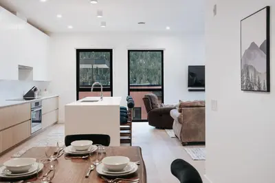a kitchen and living room with a table and chairs at Cloudscape Penthouse by Revelstoke Vacations in Revelstoke