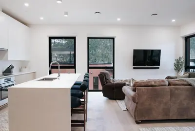 a kitchen and living room with a couch and a table at Cloudscape Penthouse by Revelstoke Vacations in Revelstoke