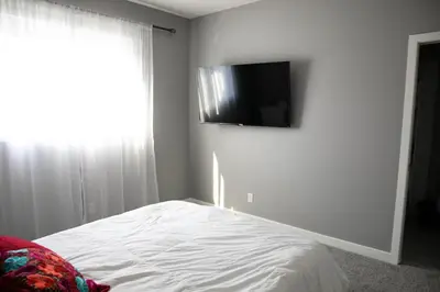 a bedroom with a bed and a flat screen tv on the wall at Scenic Cochrane Family Home in Cochrane
